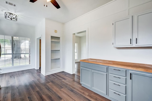 kitchen featuring dark wood-type flooring, ceiling fan, butcher block counters, and built in features