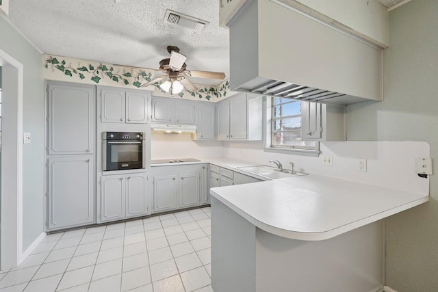 652 Birchwood Dr, Port Neches, TX 77651 - kitchen featuring oven, a peninsula, black electric cooktop, under cabinet range hood, and ceiling fan