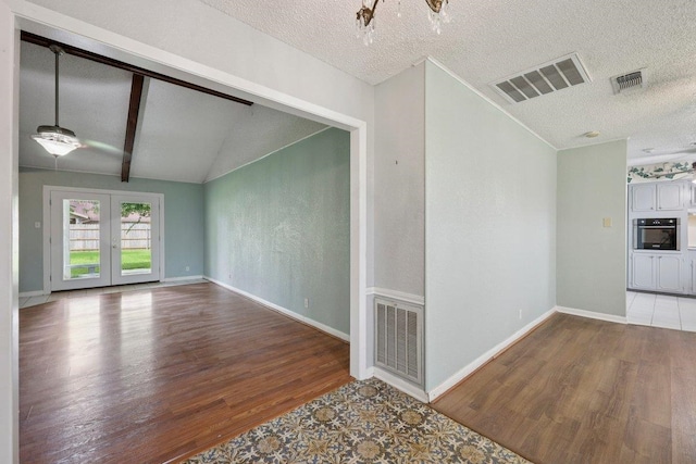 652 Birchwood Dr, Port Neches, TX 77651 - unfurnished room featuring wood finished floors, vaulted ceiling, a textured ceiling, french doors, and a ceiling fan
