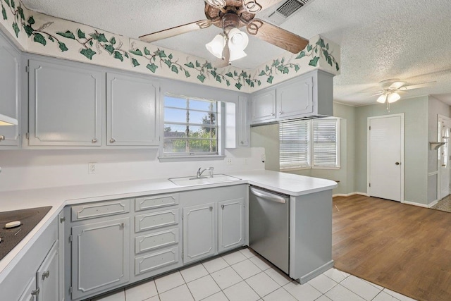 652 Birchwood Dr, Port Neches, TX 77651 - kitchen with a ceiling fan, stainless steel dishwasher, a textured ceiling, gray cabinetry, and a peninsula