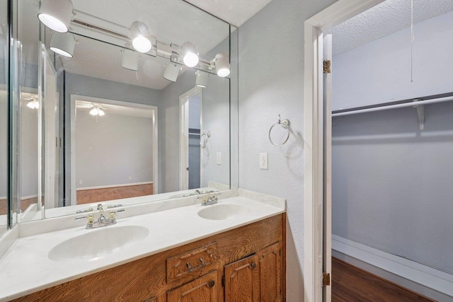 652 Birchwood Dr, Port Neches, TX 77651 - full bath with double vanity, a walk in closet, wood finished floors, and ceiling fan