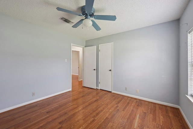 652 Birchwood Dr, Port Neches, TX 77651 - unfurnished bedroom featuring wood finished floors, a textured ceiling, and a ceiling fan
