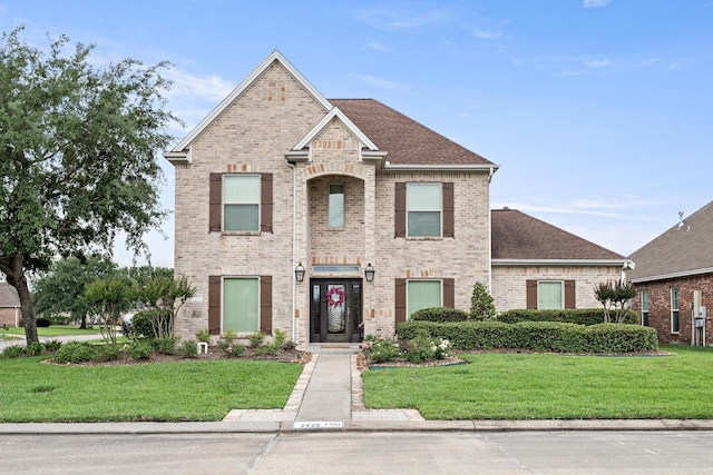 2425 Amberwood Dr, Beaumont, TX 77713 - view of front of property with roof with shingles, a front yard, and brick siding