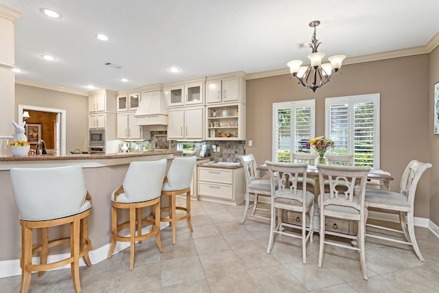2425 Amberwood Dr, Beaumont, TX 77713 - kitchen with crown molding, glass insert cabinets, premium range hood, stainless steel microwave, and a notable chandelier