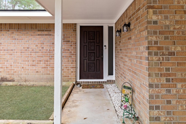 doorway to property featuring brick siding