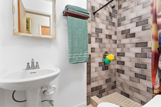 full bath with a sink and a shower stall