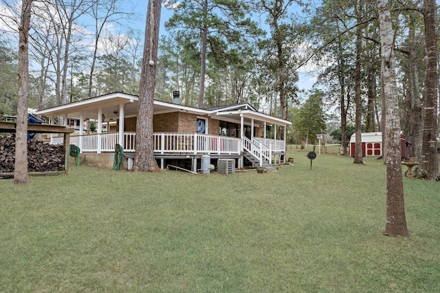 view of front facade with covered porch, a storage unit, and a front yard