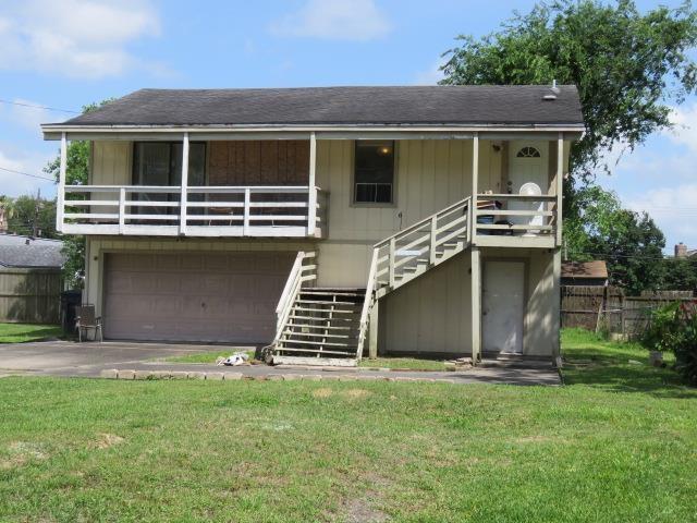 view of front of property featuring stairway, a garage, and driveway