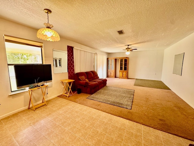 carpeted living room with a ceiling fan and a textured ceiling