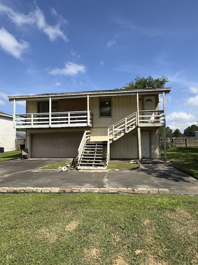 view of front facade featuring stairs, asphalt driveway, and a front lawn