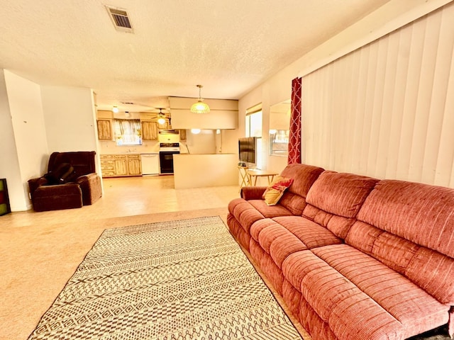 living room with healthy amount of natural light, light colored carpet, and a textured ceiling