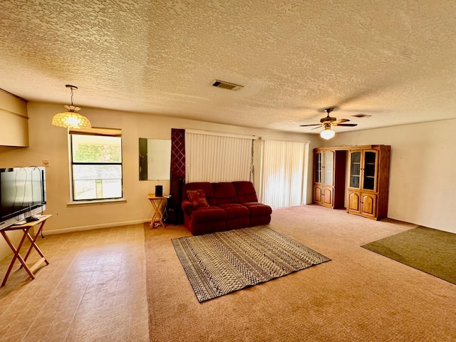 carpeted living room featuring ceiling fan, a textured ceiling, and baseboards