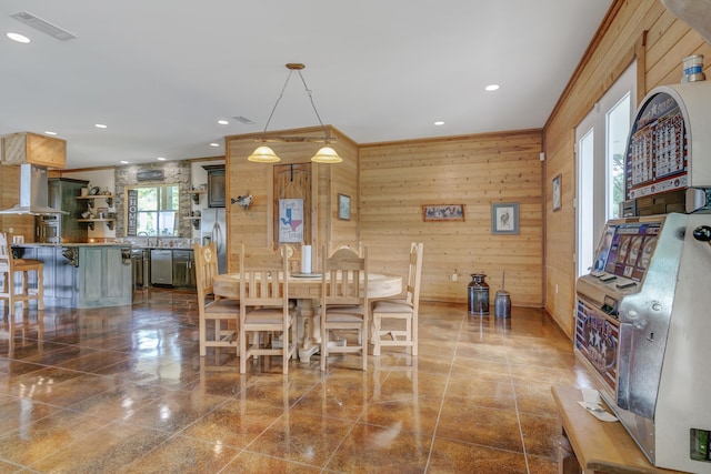 dining room featuring wooden walls and ornamental molding