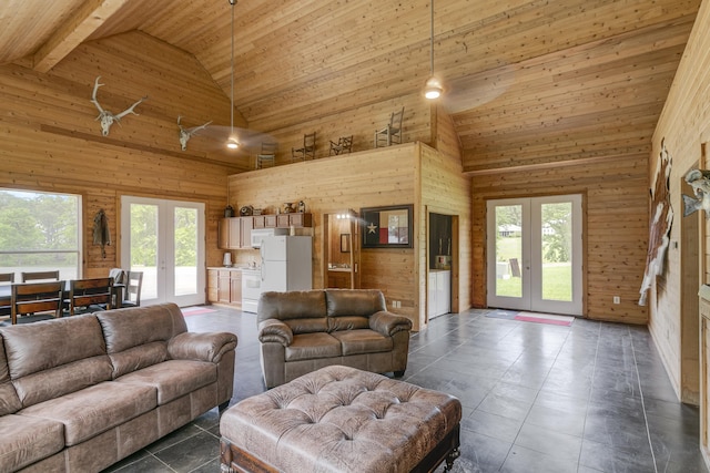 living room with french doors, high vaulted ceiling, ceiling fan, and wood walls