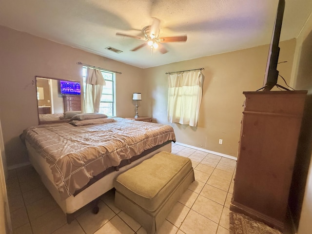 197 Osborne Dr, Bridge City, TX 77611 - bedroom with light tile patterned floors, a ceiling fan, and baseboards