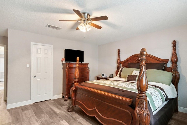 bedroom featuring a textured ceiling, light wood-type flooring, and ceiling fan