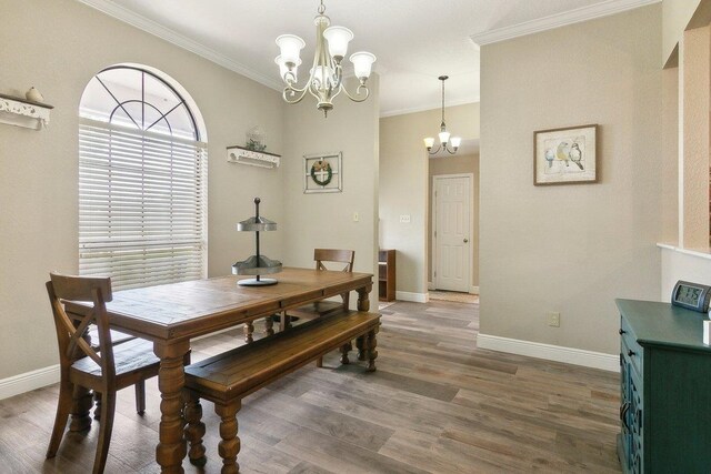 dining room with dark hardwood / wood-style flooring, a chandelier, and ornamental molding