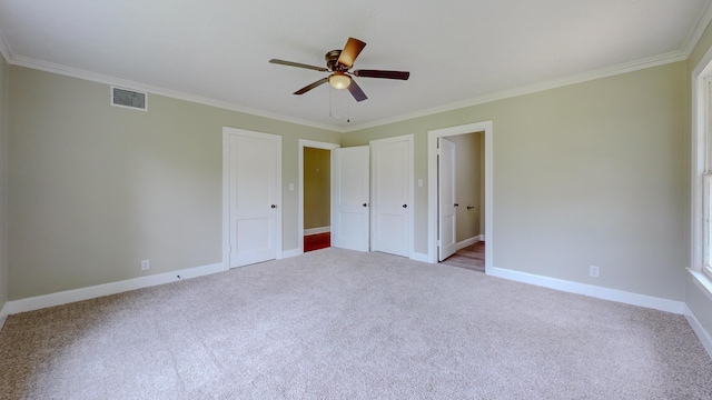 unfurnished bedroom with ceiling fan, light colored carpet, and ornamental molding