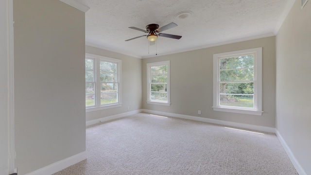 carpeted empty room with ceiling fan, ornamental molding, a textured ceiling, and a wealth of natural light