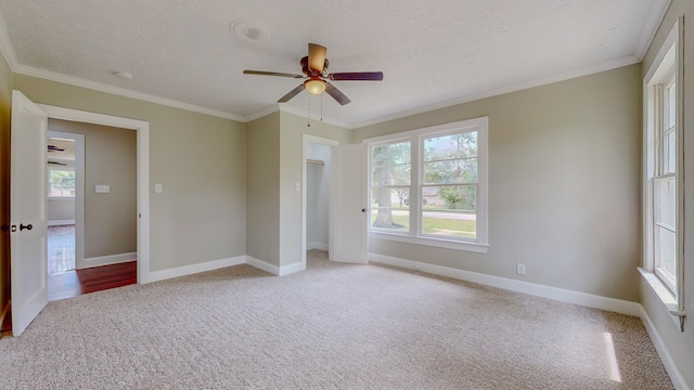 unfurnished bedroom featuring ornamental molding, a textured ceiling, light colored carpet, ceiling fan, and a closet