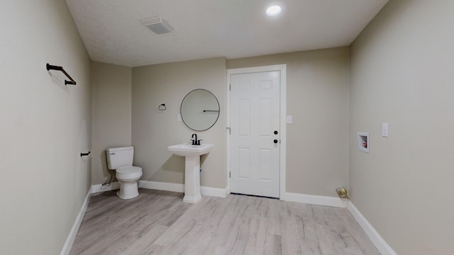 bathroom with hardwood / wood-style floors and toilet