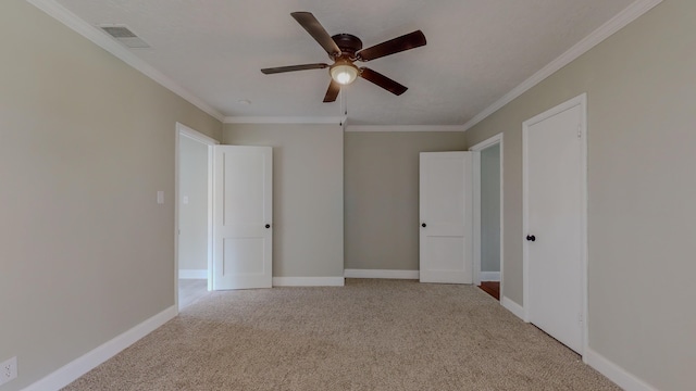 empty room featuring ceiling fan, ornamental molding, and light carpet