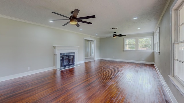 unfurnished living room featuring a textured ceiling, wood-type flooring, a fireplace, and ornamental molding