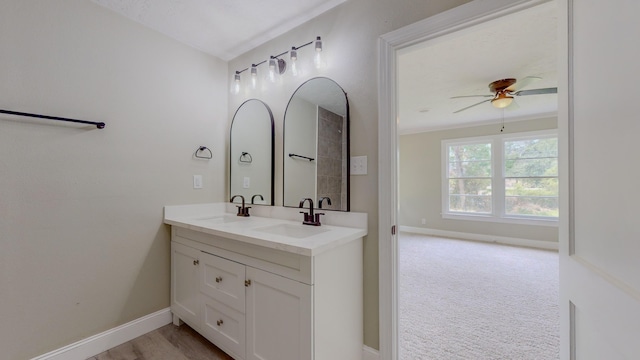 bathroom with ceiling fan, crown molding, and vanity