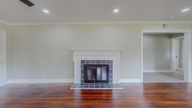 unfurnished living room with a fireplace, dark hardwood / wood-style floors, ceiling fan, and crown molding