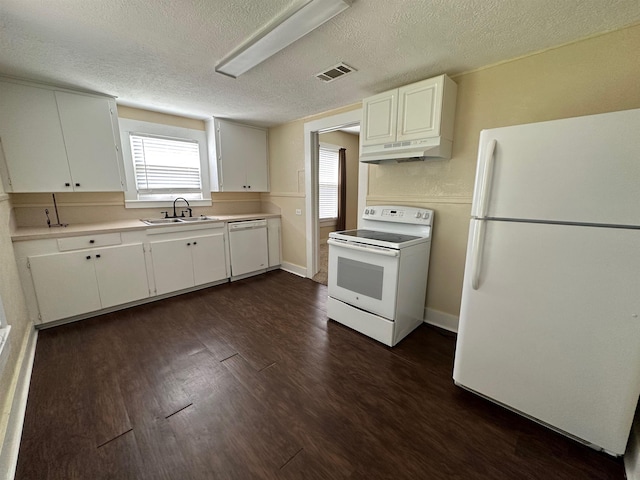 410 N 6th St, Silsbee, TX 77656 - kitchen with white appliances, under cabinet range hood, light countertops, dark wood-style floors, and white cabinets