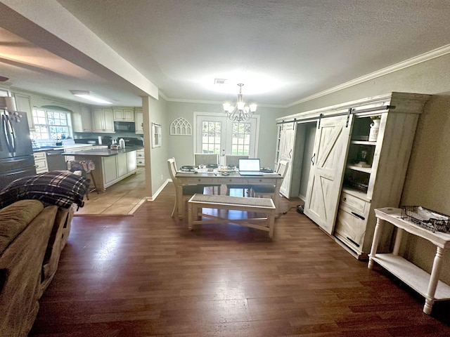 dining area with a barn door, ornamental molding, a textured ceiling, dark hardwood / wood-style flooring, and a chandelier