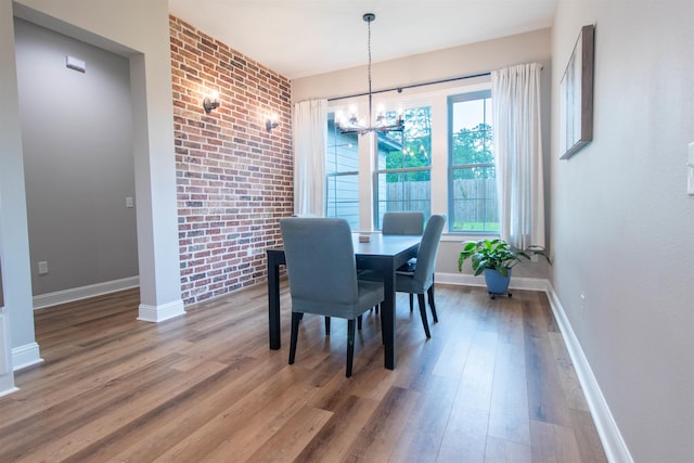 245 Balsam Bnd, Lumberton, TX 77657 - dining room featuring a chandelier, wood finished floors, baseboards, and brick wall
