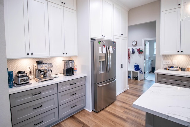245 Balsam Bnd, Lumberton, TX 77657 - kitchen featuring stainless steel fridge, gray cabinets, light wood finished floors, and decorative backsplash