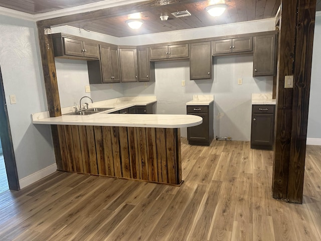 127 Hilldale Dr, Nederland, TX 77627 - kitchen with a sink, a peninsula, light wood finished floors, light countertops, and crown molding