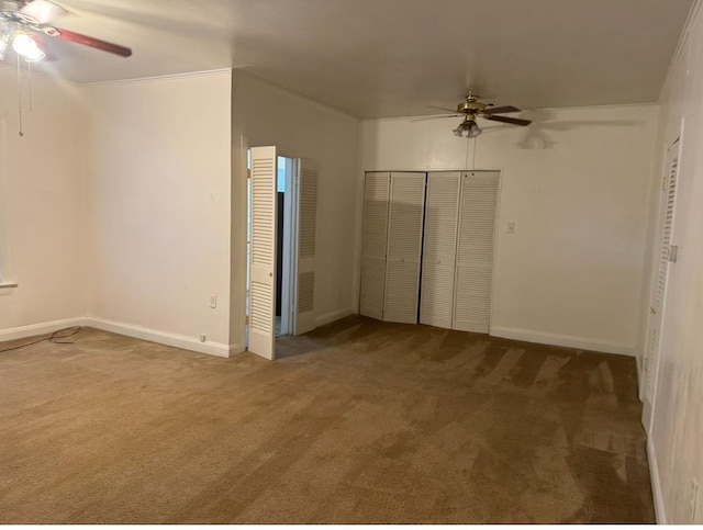 unfurnished bedroom featuring ornamental molding, carpet flooring, ceiling fan, and a closet