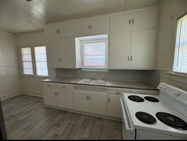 kitchen featuring white cabinets, sink, dark wood-type flooring, and electric range