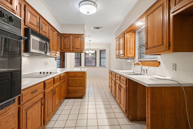 1911 Huntsman St, Orange, TX 77632 - kitchen with black appliances, a sink, light countertops, a textured ceiling, and light tile patterned flooring