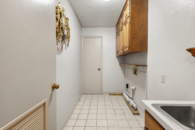 1911 Huntsman St, Orange, TX 77632 - laundry area featuring cabinet space, light tile patterned floors, a textured ceiling, and hookup for a washing machine