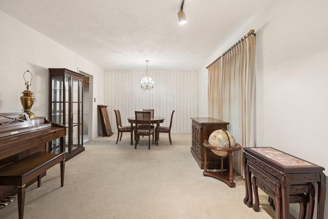 1911 Huntsman St, Orange, TX 77632 - dining area featuring light carpet, a chandelier, and a textured ceiling