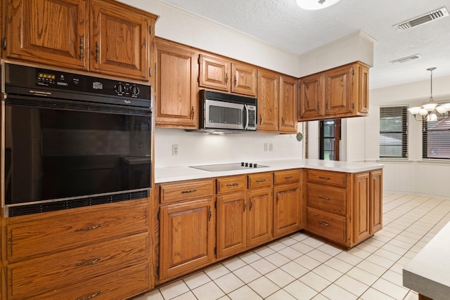 1911 Huntsman St, Orange, TX 77632 - kitchen with black appliances, light countertops, brown cabinets, a peninsula, and a chandelier