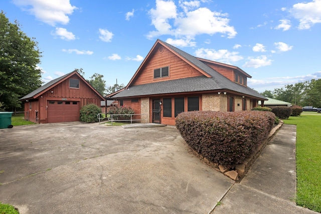 1911 Huntsman St, Orange, TX 77632 - view of front of property with a detached garage, an outdoor structure, a shingled roof, driveway, and brick siding
