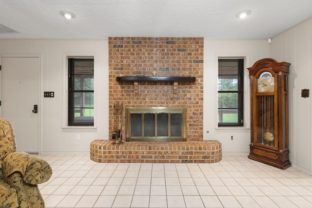 1911 Huntsman St, Orange, TX 77632 - living room featuring a fireplace, baseboards, a textured ceiling, and light tile patterned floors
