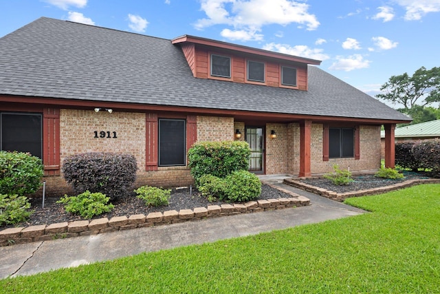 1911 Huntsman St, Orange, TX 77632 - view of front of house with brick siding, a shingled roof, and a front lawn