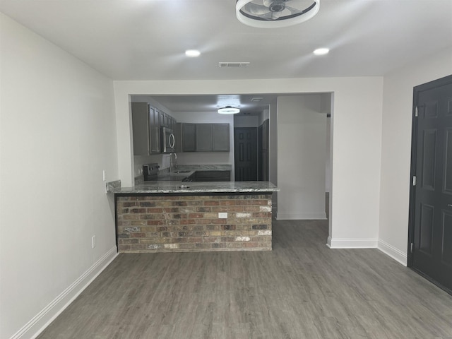 kitchen featuring sink, kitchen peninsula, and dark wood-type flooring