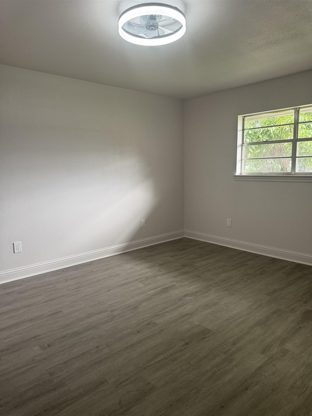 unfurnished room with dark wood-type flooring