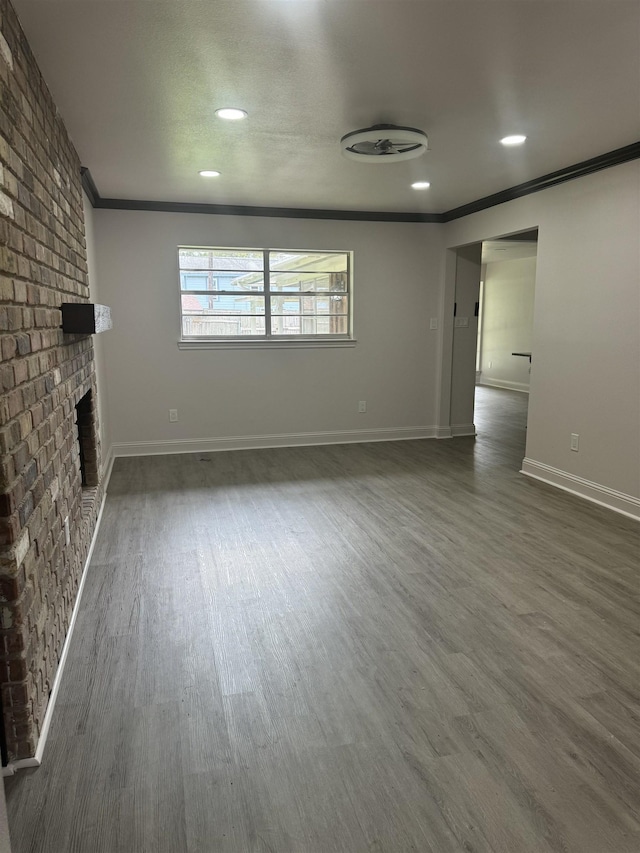 unfurnished living room with crown molding, dark hardwood / wood-style floors, and a brick fireplace