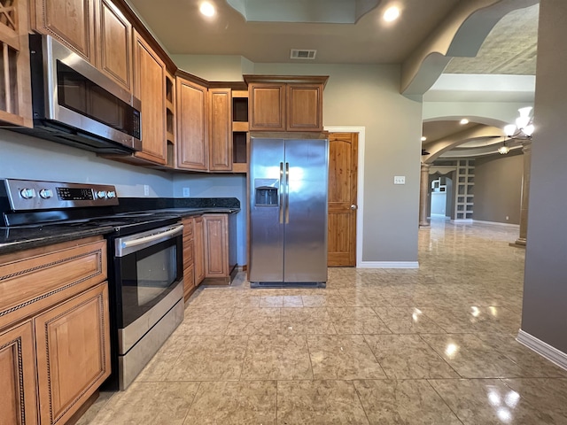 kitchen with appliances with stainless steel finishes and dark stone countertops