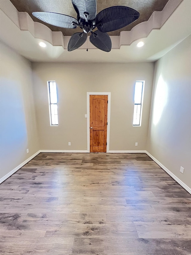 unfurnished room with ceiling fan, wood-type flooring, and a healthy amount of sunlight