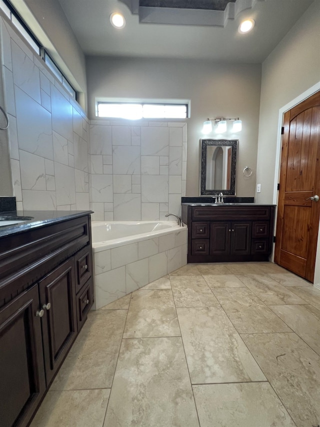 bathroom with vanity and a relaxing tiled tub