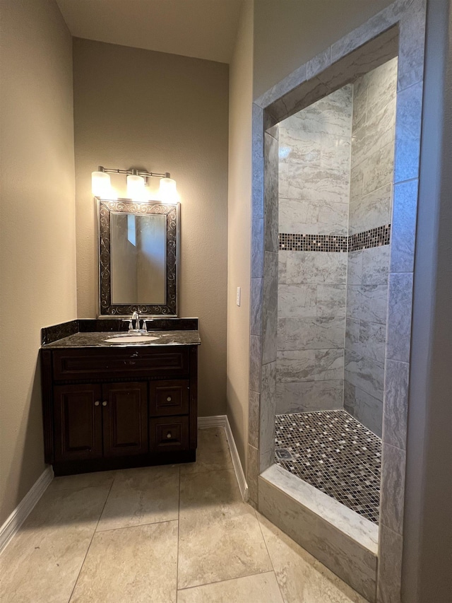 bathroom featuring a tile shower, vanity, and tile patterned floors